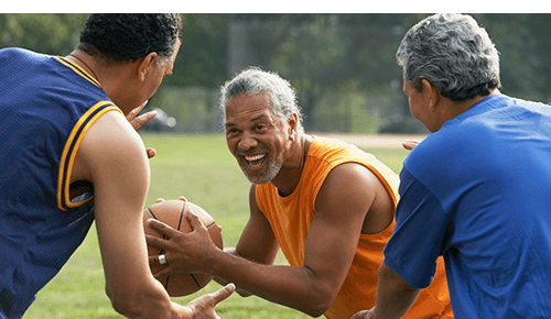 Three older adults playing basketball outside Three older adults playing basketball outside
