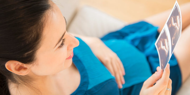 Pregnant person holding an ultrasound