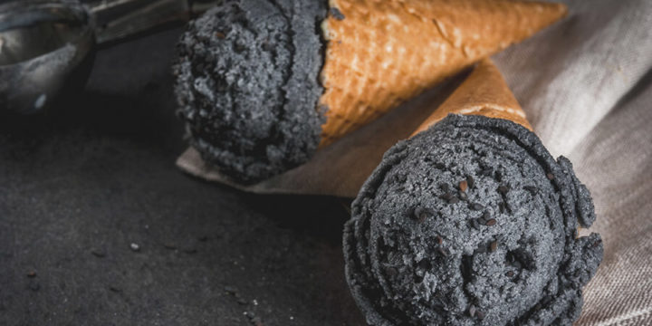 Scoops of black charcoal ice cream in waffle cones