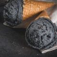 Scoops of black charcoal ice cream in waffle cones