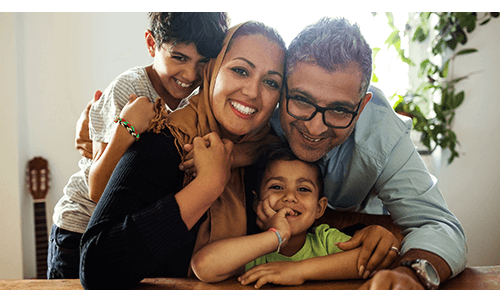 Family hugging and smiling into camera Family hugging and smiling into camera