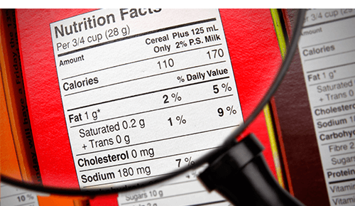 Closeup of nutrition label on food packaging using magnifying glass