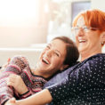Adult child hugging smiling mother