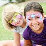 Two children smiling at camera with their faces painted