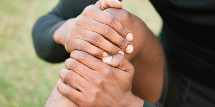 Person holding their knee in pain