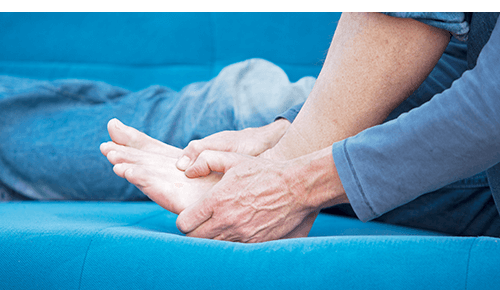 Person holding their foot in pain Person holding their foot in pain