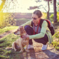 Woman on hike checking for ticks on dog