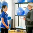 Woman talking to exercise physiologist in gym