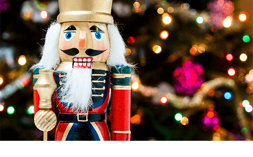 Closeup of nutcracker in front of a holiday tree