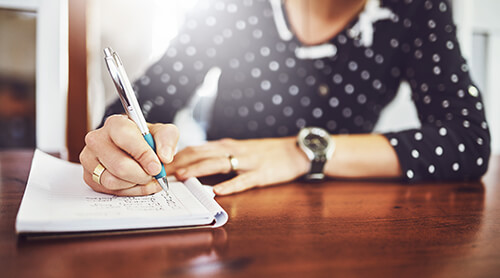 Closeup of person writing on a piece of paper