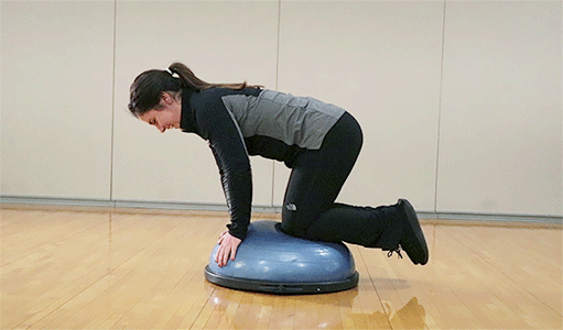 Side view of person performing Bird Dog Exercise on balance ball
