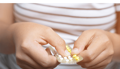 Closeup of someone taking a pill out of a medicine package Closeup of someone taking a pill out of a medicine package