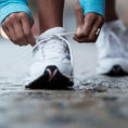 Closeup of person tying their shoe while on a walk