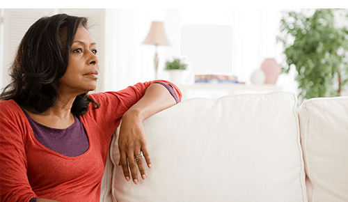 Woman sitting on couch looking into distance
