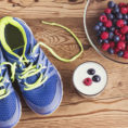 Athletic shoes sitting on ground next to healthy foods