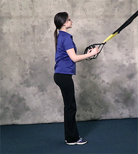 Person performing Curtsy Lunge to High Knee TRX Exercise