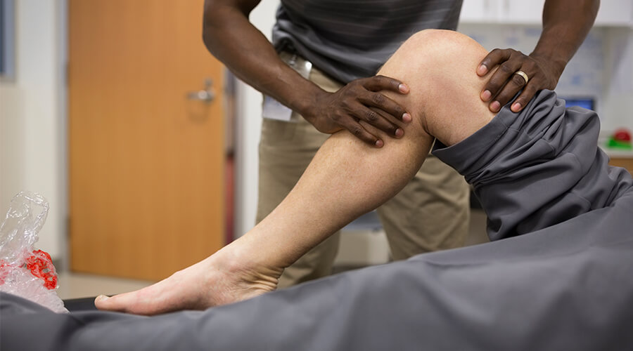Physical therapist examining a patient's hurt knee Physical therapist examining a patient's hurt knee