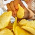 Closeup inside of potato chip bag as a hand pulls out a potato chip