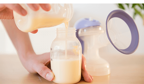 Woman Pouring Breast Milk into Bottle