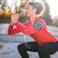 Woman performing squat exercises while working out outdoors
