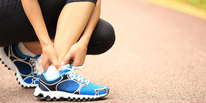 Closeup of person holding ankle bottom of leg in pain