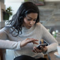 Person looking at mobile phone at cafe