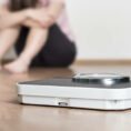 Weight scale with person sitting on ground in background