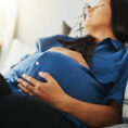 Pregnant woman asleep with hands on stomach
