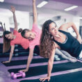 Group performing side plank exercises in gym