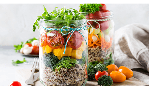 Two mason jars with salads in them