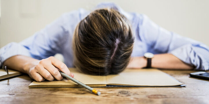 Stressed person with head on table