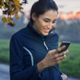 Woman looking at phone while on a walk outside