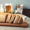 Gluten free beer bread sitting on cutting board on counter in front of a glass of beer