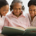 Grandmother and grandchildren looking at book together