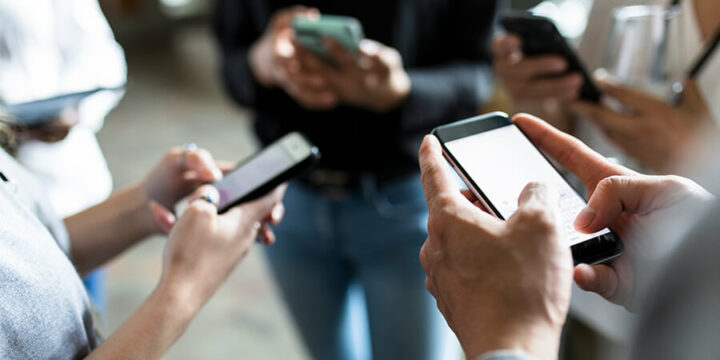 Group all looking at their mobile phones