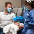Person wearing a mask receiving infusion therapy