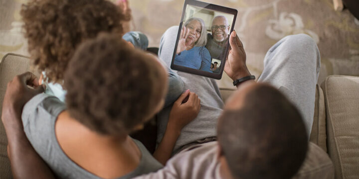 Family talking to grandparents virtually on tablet