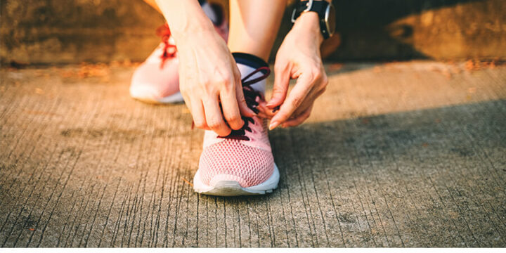 Person tying laces of athletic shoe