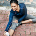 Woman stretching legs on ground before exercise