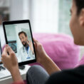 Person talking to doctor during virtual visit on tablet