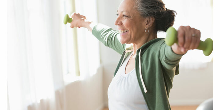 Smiling woman working out with dumbbells