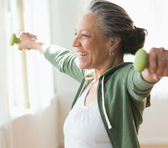 Smiling woman working out with dumbbells
