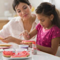 Mother and child decorating pink heart cookies for Valentine's Day
