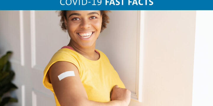 Smiling person holding up arm with band-aid on it
