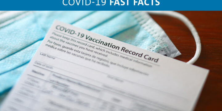 Proof of vaccine card sitting next to mask