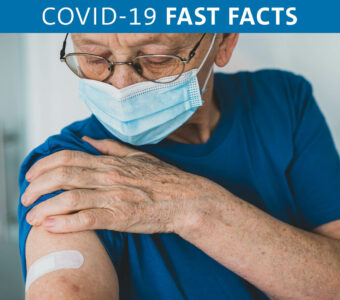 Person holding arm with a band-aid on it after receiving COVID-19 vaccination