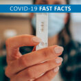 Hand holding a COVID-19 antigen test that reads positive in results window