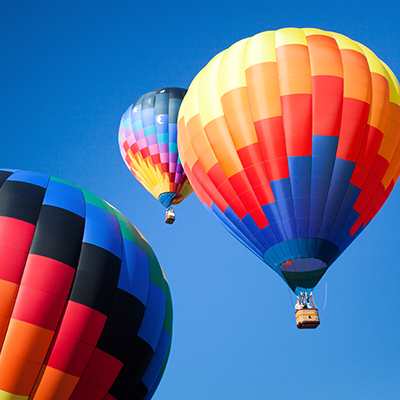 Multiple hot air balloons at a festival