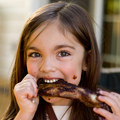Child eating ribs at festival