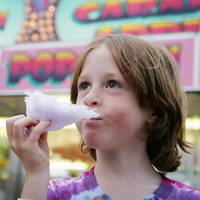 Child eating cotton candy at festival
